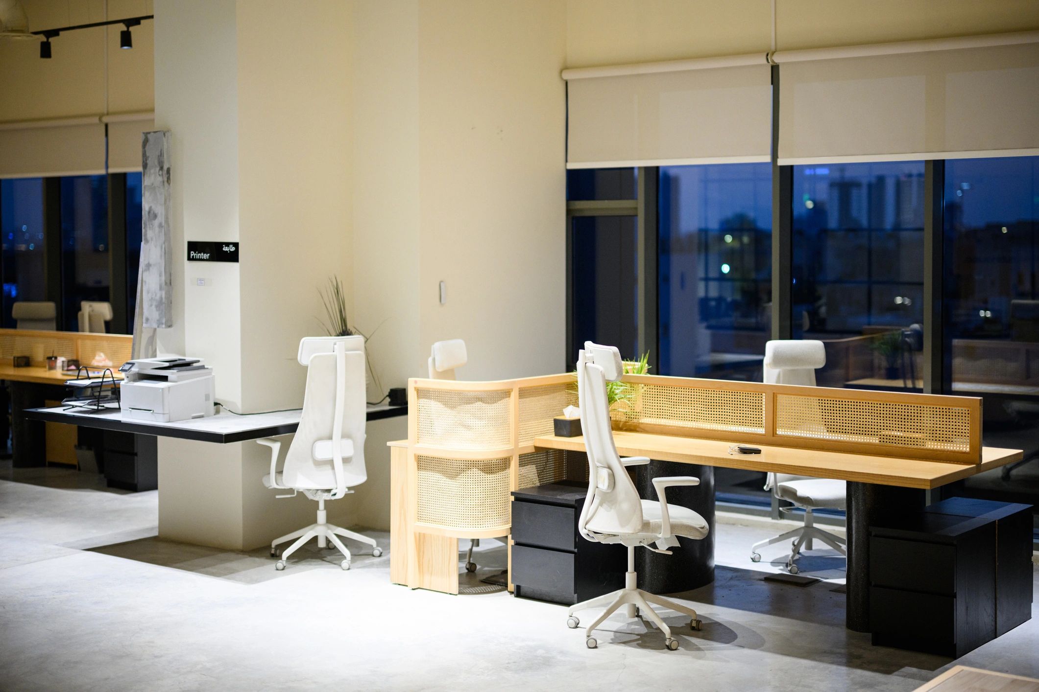Modern professional office workspace with desks and large windows
